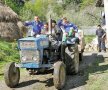 Călare pe tractor,
alături de călugări