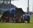 Robert Nita (stinga) asista cum prietenul sau Catalin Danilescu le da indicatii micutilor fotbalisti sub o umbrela cu rol de banca de rezerva. Afara erau 38 de grade!