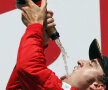 Fernando Alonso îşi toarnă cu dexteritate şampanie direct în gură // Foto: Reuters