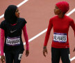 Noi ce căutăm aici? Fatima, din Yemen (stînga), şi Shinoona, din Oman, par aterizate pe Lună pentru o serie olimpică de 100 m la atletism.