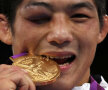 Ochiul care nu vede aurul. Sud-coreeanul Kim muşcă medalia cea mai preţioasă, dar ochiul său drept e închis complet după şocurile de la greco-romane // Foto: Reuters