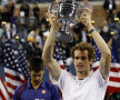 Andy Murray ridică primul trofeu de Mare Şlem al carierei, US Open 2012, iar Novak Djokovici studiază tava finalistului // Foto: Reuters