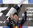 Vettel celebrează trofeul primit pentru cursa din Japonia.
