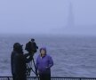 Înainte de declanșarea
uraganului, o echipă TV
se pregătește de
transmisie, cu Statuia
Libertății înecată în nori