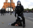 Un poliţist stă cu genunchiul pe un ultras al lui PSG // Foto: Reuters