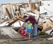 Un părinte și doi
copii ies din buncăr
după furtună