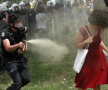 O femeie atacată de poliţişti cu gaze lacrimogene // Foto: Reuters