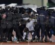 Jucătorii ghanezi părăsesc terenul sub protecția scuturilor
