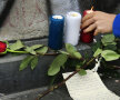 MESAJE ŞI FLORI. Un trandafir, o scrisoare aşternută în grabă, pe un petic de hîrtie, şi lumînările tricolore Foto: Reuters