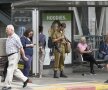 Viața de lîngă buncăr. În Israel, oamenii s-au obișnuit să trăiască printre arme. Un militar așteaptă autobuzul într-o stație din Tel Aviv. Foto: Raed Krishan