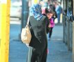 O mamă cu fetița ei se plimbă liniștite pe străzile orașului