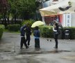 Câțiva spectatori așteaptă să vadă dacă vremea se va îndrepta