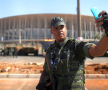 Selfie la datorie. Un soldat brazilian își face o poză în fața stadionului Mane Garrincha din Brasilia, una dintre arenele ce vor găzdui competițiile JO, în timpul simulării unei manevre de securitate. Foto: Reuters