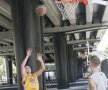 Doi tineri se antrenează la coșul de baschet