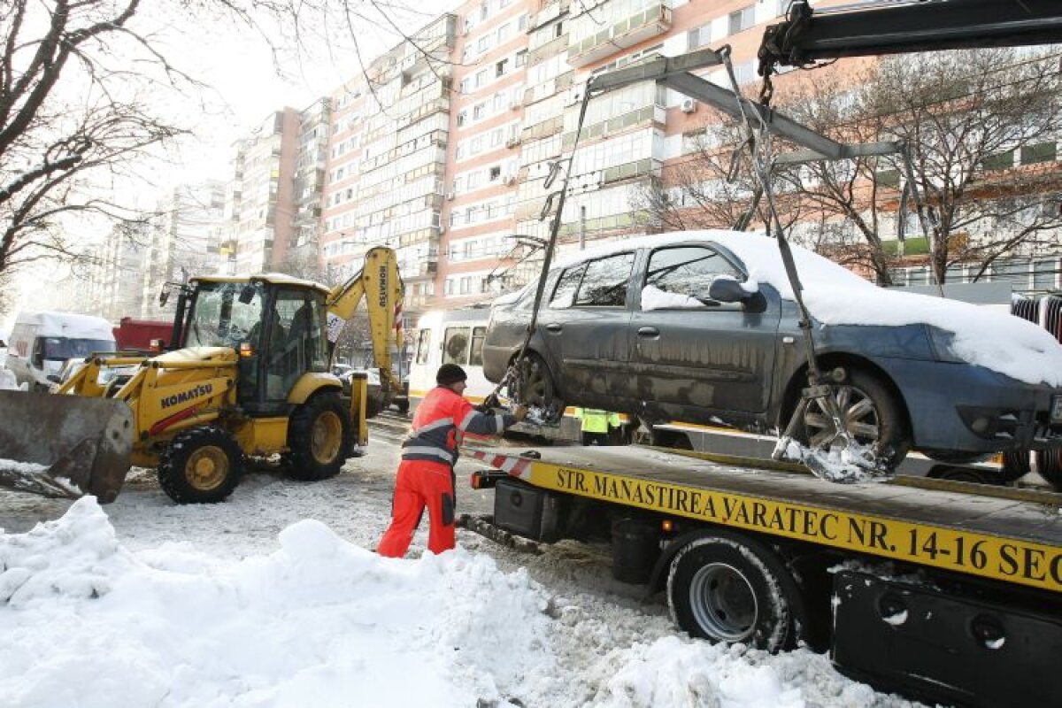 Cale liberă » Maşinile sînt ridicate pentru a facilita deszăpezirea, apoi sînt puse la loc