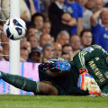 Petr Cech priveşte speriat cum mingea ricoşată din el se îndreaptă spre plasă // Foto: Reuters
