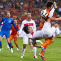 Duel aerian pentru balon, cu turcul Arda Turan (în alb) și olandezul Janmaat în prim-plan // Foto: Reuters