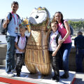 Eduard şi Laura Novak alături de copii, de mascota aurie cu un fundal caracteristic Londrei