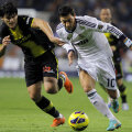 Săpunaru (stînga) se agaţă de Ozil în meciul cu Real de pe "Bernabeu" // Foto: Reuters