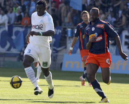 Taye Taiwo de la Marseille (stînga), într-un duel cu John Utaka de la Montpellier