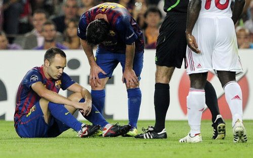 Andres Iniesta (stînga) s-a accidentat aseară, contra lui AC Milan