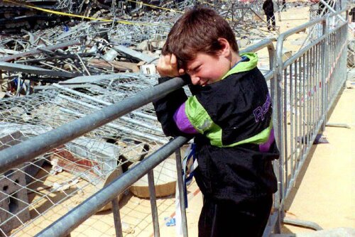 Un copil plînge în fața victimelor îngropate printre tuburile metalice din tribuna Nord