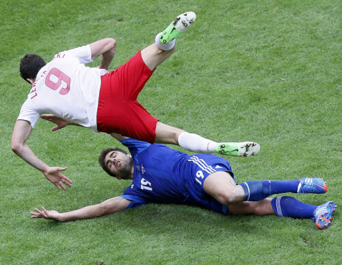 Un exemplu de tackling agresiv al grecului Papastathopoulos (în albastru). Polonezul Lewandowski zboară după atacul fundaşului // Foto: Reuters