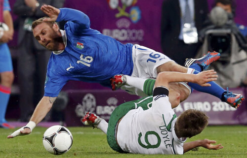 Italianul De Rossi (în albastru, atacat violent de irlandezul Doyle) a fost unul dintre ultimii jucători văzuţi de fanul chinez la Euro // Foto: Reuters