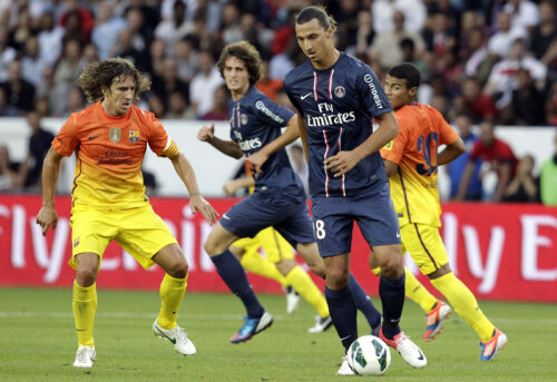 Ibrahimovici (dreapta, în duel cu Puyol) e cel mai bine plătit din Ligue 1, 14 milioane de euro anual pînă în 2015 // FotoL: Reuters