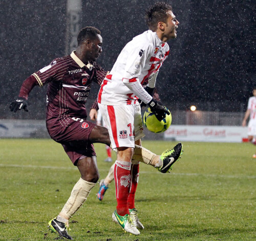 Adversarii nu l-au cruţat pe Mutu. Fundaşul lui Valenciennes vrea să respingă mingea printre picioarele românului // Foto: AFP/Mediafax