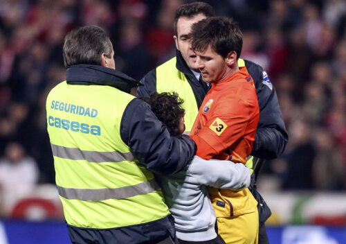 Un puşti se agaţă de Messi. Oamenii de ordine încearcă să-l tragă pe băiat // Foto: Reuters