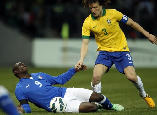 Balotelli (stînga) nu mai scapă de atacul dur al lui David Luiz, căpitanul Braziliei. Italianul e la pămînt // Foto: Reuters