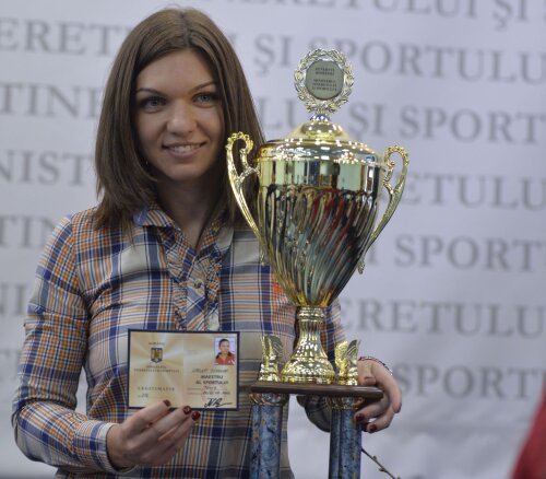 Simona Halep zîmbește lîngă trofeul pe care l-a primit de la MTS // Foto: Cristian Preda