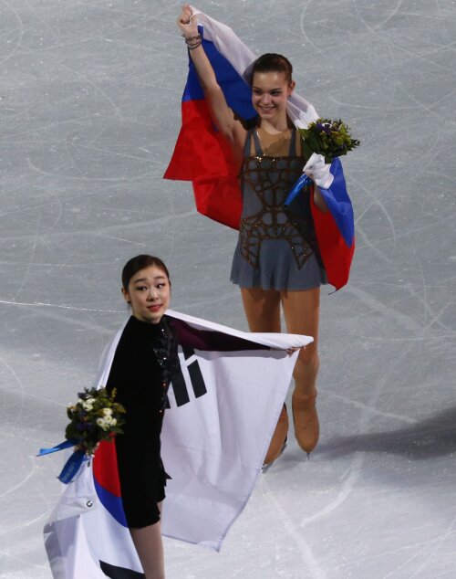 Adelina Sotnikova flutură fericită stagul rusesc. Cu drapelul ţării pe gheaţă, Yuna Kim este, în ochii unora, adevărata campioană olimpciă