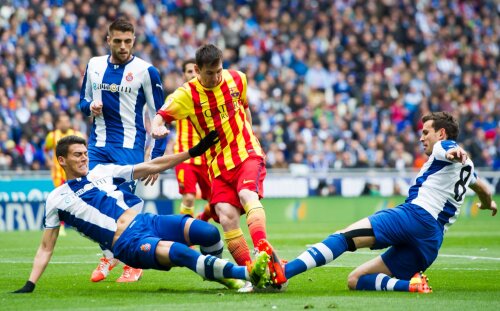 Căderea Barcelonei a coincis cu dispariția din joc a lui Messi, aruncat în aer aici de doi adversari în derbyul catalan // Foto: Guliver/GettyImages