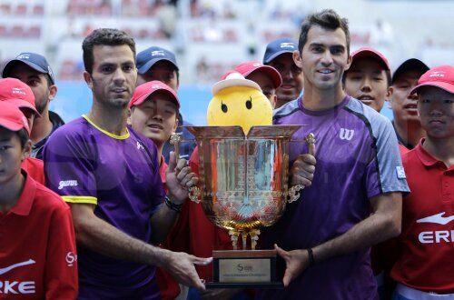 Jean-Julien Rojer (stînga) şi Horia Tecău zîmbesc cu trofeul, mascota şi copiii de mingi de la Beijing // Foto: Reuters