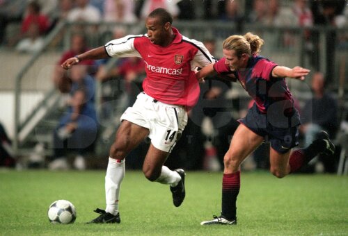 Henry (stînga) și Petit într-un duel Arsenal - Barcelona. Cei doi au fost campioni mondiali (1998) și europeni (2000) cu Franţa