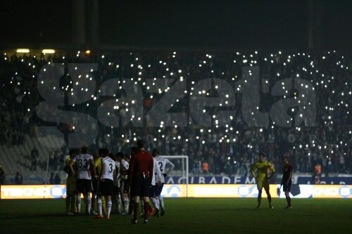 Jucătorii în beznă, tribunele și reclamele luminate. E adevărat, și cu ajutorul lanternelor de la smartphone-uri // Foto: Reuters