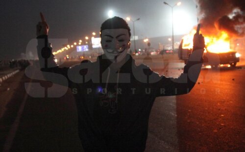 Isterie la Cairo. Un fan mascat în faţa unei maşini de poliţie în flăcări