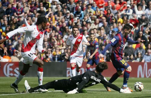 Messi (dreapta) driblează portarul şi mai înscrie o dată în poarta lui Rayo // Foto: Reuters