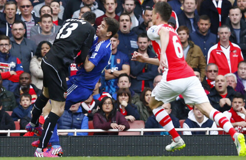 Portarul Arsenalului, Ospina, îl lovește pe Oscar, care reușise să lobeze balonul peste el. Arbitrul n-a văzut însă penalty // Foto: Reuters