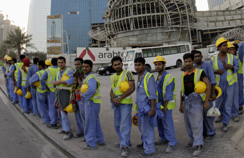 Contrastele CM 2022, muncitorii istoviți așteaptă autobuzele în fața unui luxos hotel din Doha // Foto: Reuters