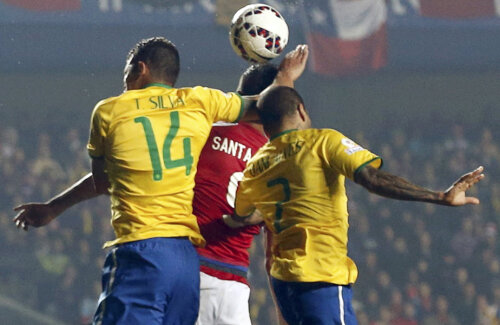 Thiago Silva (nr. 14) sare peste Dani Alves și blochează mingea cu mîna deasupra lui Santa Cruz // Foto: Reuters