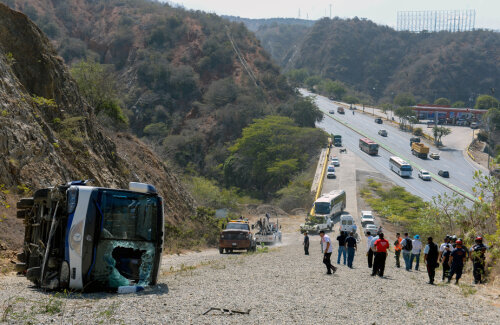 Autocarul răsturnat, cu parbrizul spart. Jos, în vale, autostrada. Dacă ar fi rămas acolo, ar fi putut muri toți la Huracan // Foto: AFP