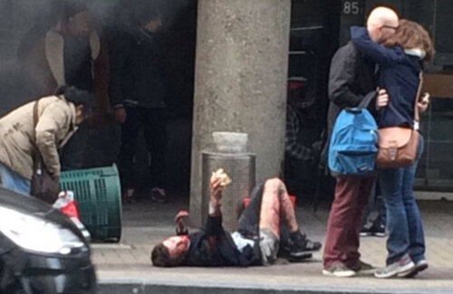 Imagine șocantă ieri, la Bruxelles: un cuplu se îmbrățișează cu spatele la un bărbat căzut și plin de sânge