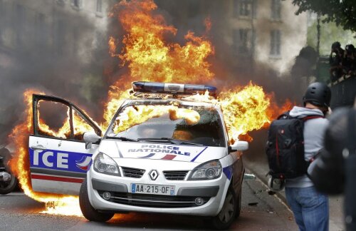 Mașina poliției, un Renault Scenic, în flăcări // FOTO Reuters