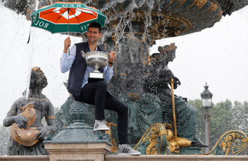 Novak Djokovici a pozat cu trofeul de la Roland Garros în Place de la Concorde, adăpostindu-se sub umbrelă de stropii fântânii // FOTO Reuters