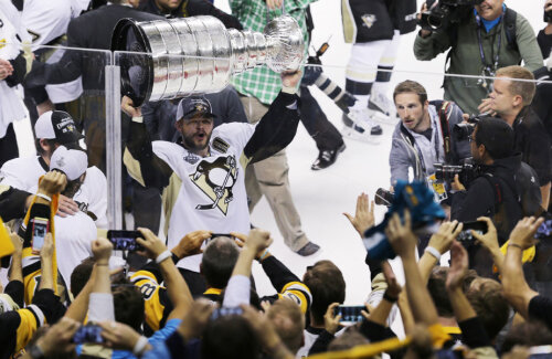 Chris Kunitz de la Penguins le arată fanilor Cupa Stanley și sărbătoresc împreună // Foto: Reuters