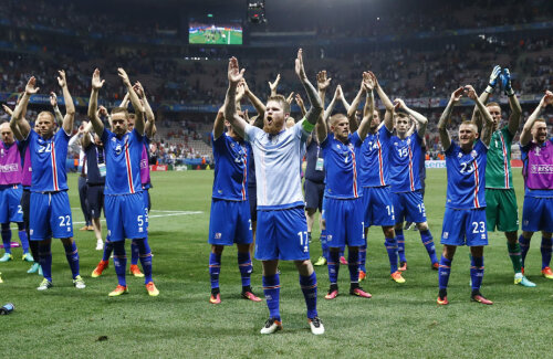 Bărbosul Gunnarrson, un fost handbalist, dirijează sărbătoarea victoriei. Islandezii bat din palme împreună cu fanii // Foto: Reuters