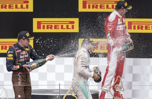 Lewis Hamilton în centrul duşului cu şampanie iniţiat de Max Verstappen (stânga) şi Kimi Raikkonen (dreapta), după a treia sa victorie din acest sezon // FOTO AFP